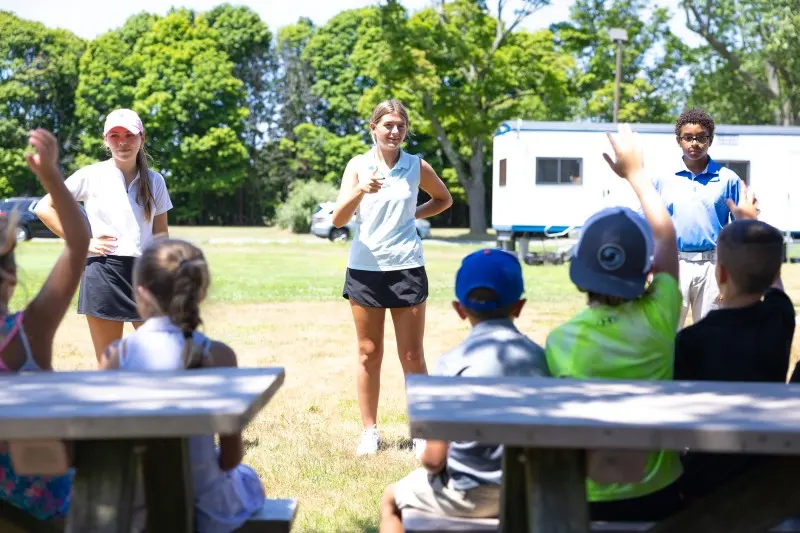 Coaches talk with juniors at the picnic tables