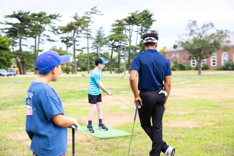 A coach and a junior on the range