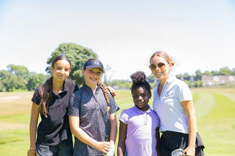 Two coaches with a young golfer