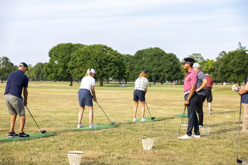 Adult students hitting balls on the range