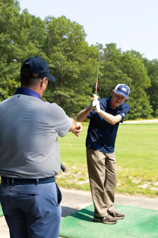 An instructor coaches a veteran’s swing